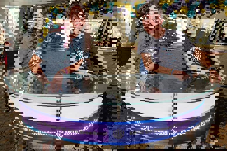 A diverse crowd of people celebrating at a concert, raising their hands and cheering.