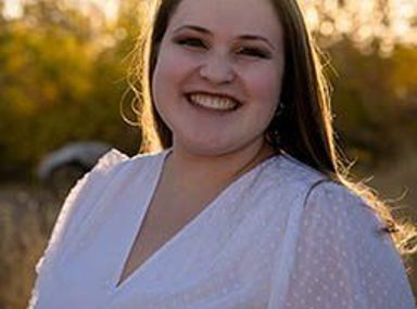 A diverse crowd of people celebrating at a concert, raising their hands and cheering.