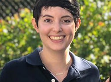 A diverse crowd of people celebrating at a concert, raising their hands and cheering.