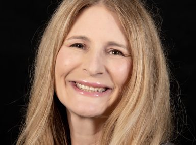 A diverse crowd of people celebrating at a concert, raising their hands and cheering.