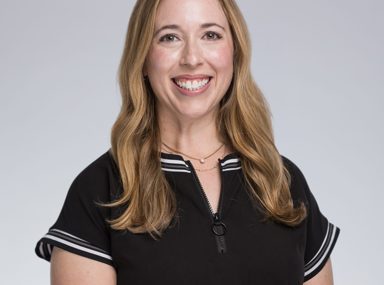 A diverse crowd of people celebrating at a concert, raising their hands and cheering.