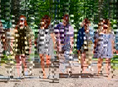 A diverse crowd of people celebrating at a concert, raising their hands and cheering.